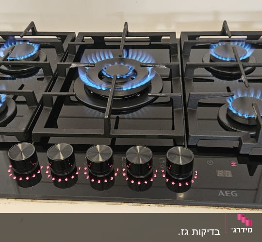 כיריים גז עם להבות כחולות וכפתורי שליטה